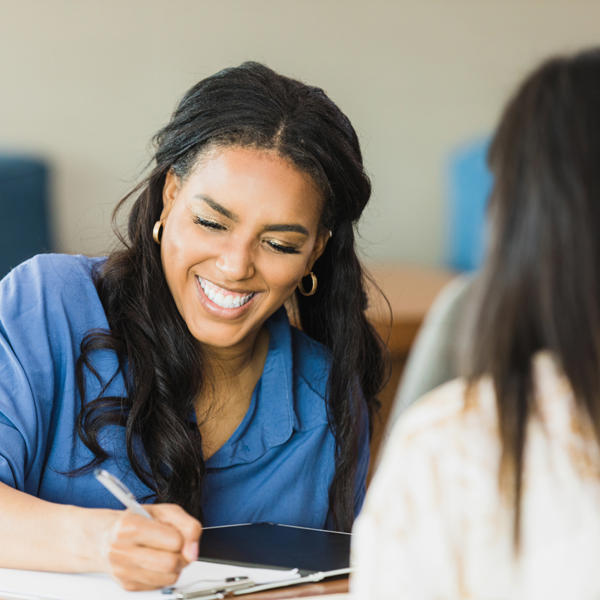 Woman signing paperwork - stock